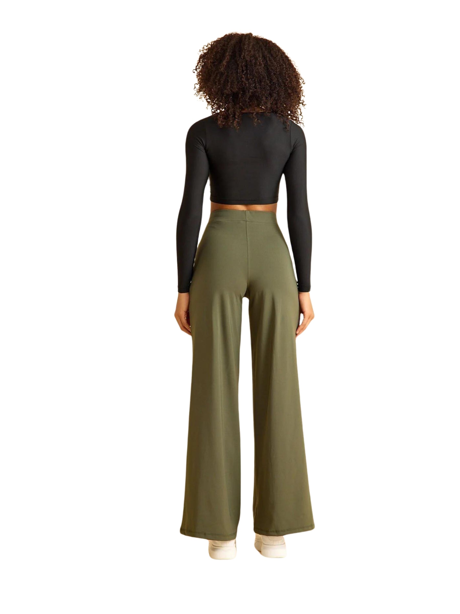 Person mit Locken in einem schwarzen langärmligen bauchfreien Top und Lisminas 450 Mumbai Yoga Hose in Khaki.